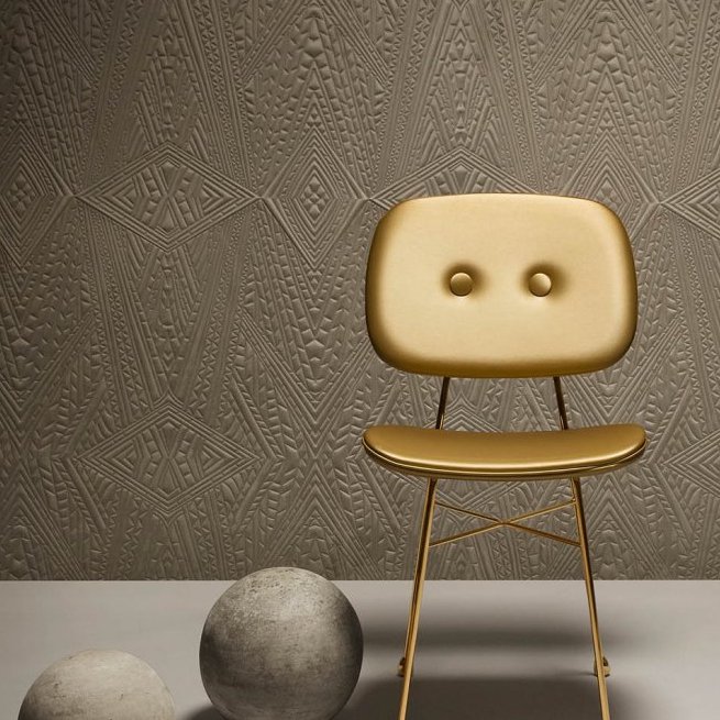Gouden designstoel voor een muur met reliëfbehang uit de Moooi Dwarf Rhino collectie.