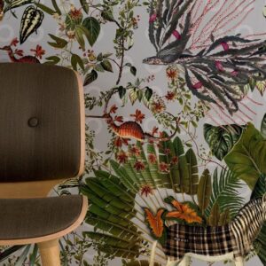 Behang met een fantasierijk junglepatroon uit de Moooi Menagerie of Extinct-collectie, naast een houten stoel met donkere stoffering.