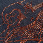 Detail van het Moooi-behang Tokyo Blue Indigo Macaque met een koperkleurige lijntekening van een makaak op donkerblauwe achtergrond.