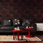 Donker interieur met Moooi-behang Tokyo Blue Indigo Macaque, zwarte bank, rode tafeltjes en Japanse accenten.