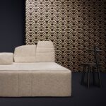Beige bank voor een wand met het zwart-gouden patroonbehang Moooi Tokyo Blue Lucky O's.