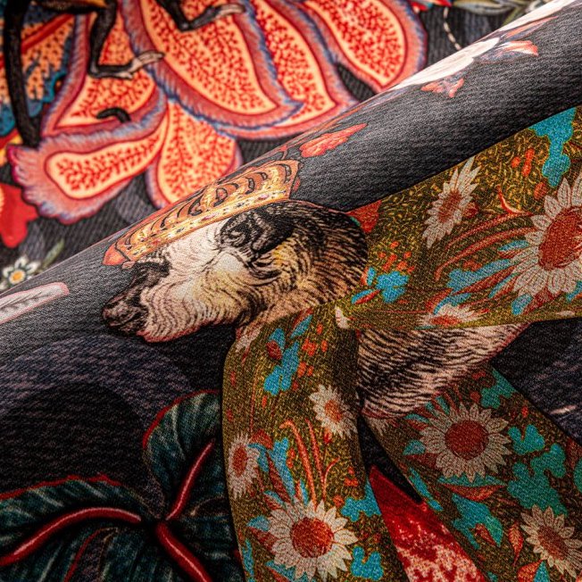 Detail van het Moooi-behang "Tokyo Blue Rendezvous" met kleurrijke bloemmotieven en een dierfiguur met kroon.