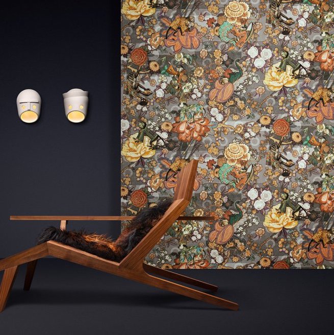 Designinterieur met Moooi-behang Tokyo Blue Rendezvous en een houten loungestoel tegen een donkere muur.