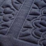 Donkerblauw Moooi-behang Tokyo Blue Shoji Blossom met een reliëfrijk bloemen- en lijnpatroon.