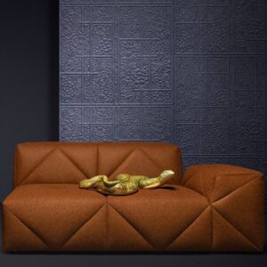 Moderne oranjebruine bank voor een muur met donkerblauw Moooi Tokyo Blue Shoji Blossom-behang en een decoratieve glimmende goudkleurige slang op de zitting.