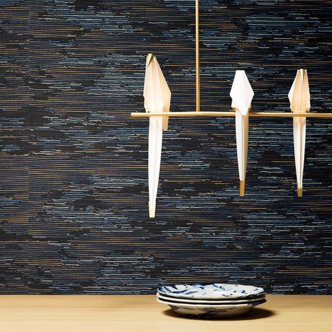 Modern interieur met Moooi-behang Tokyo Blue Tie Tami, een minimalistisch lichtarmatuur en gestapelde keramische borden.