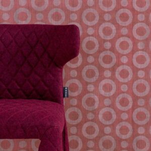 Donkerrode designstoel met ruitpatroon voor roze Moooi-behang met cirkelmotief uit de Umbrella Squid-serie.
