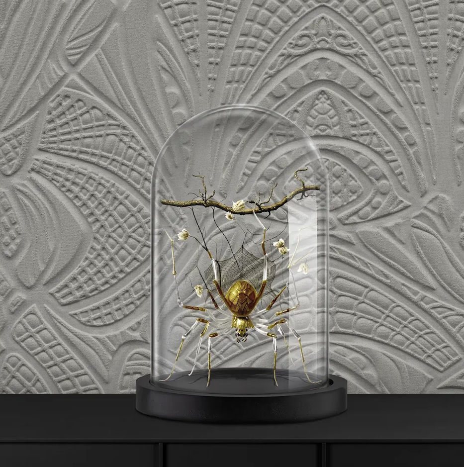Decoratieve stolp met een kunstzinnige gouden spin en takken tegen een reliëfbehang uit de Moooi Wallcovering Lacy Longlegs collectie.