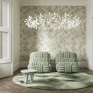 Moderne zithoek met twee mintgroene stoelen, een ronde tapijt, een kleine bijzettafel en Silk Bombis MU5012 wandbekleding van Moooi.