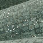 Detailopname van verweerde mozaïektegels op het oppervlak van een gebogen structuur, getiteld Mosaico5-VRMQ-3.