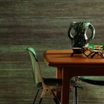 Houten tafel met groene designstoelen, een groen-zwarte Sinabaye vaas en keramiek op een gestreepte groene achtergrond.