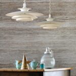 Twee moderne, witte Sinabaye3 hanglampen boven een houten tafel met servies en een waterkan.