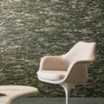 Crèmekleurige designstoel voor een muur met gemêleerd groen-beige Orrizonte2-9DOW-2 behangpatroon.