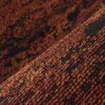 Close-up van de textuur van de Orrizonte3-EF7Y-2 meubelstof in warme roodbruine en zwarte tinten.