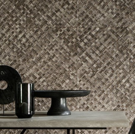 Behang met een gevlochten pandanpatroon van Arte, achter een sobere tafel met decoratieve objecten.