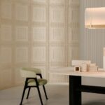 Modern interieur met een lichtgroene stoel, een tafel met decoratieve objecten en een wand met reliëfafwerking uit de Pantheon1-1R1X-2 collectie.