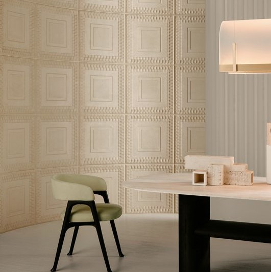 Modern interieur met een lichtgroene stoel, een tafel met decoratieve objecten en een wand met reliëfafwerking uit de Pantheon1-1R1X-2 collectie.