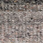 Close-up van een grof geweven wollen vloerkleed in gemêleerde bruintinten uit de Perletta Limone Fade Brown collectie.