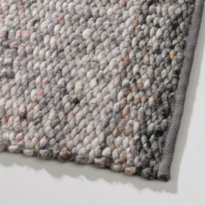 Close-up van een Perletta Limone Fade Brown vloerkleed met grove, geweven structuur en grijze rand.