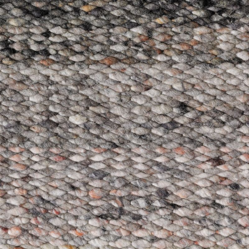 Close-up van een grof geweven wollen vloerkleed in gemêleerde bruintinten uit de Perletta Limone Fade Brown collectie.