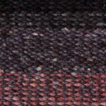 Detailopname van een grof geweven Perletta Limone vloerkleed in de kleur Fade Purple met paars-roze kleurverloop.