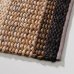 Detailopname van het Perletta Limone Fade Yellow vloerkleed met een gele tot donkere kleurverloop en grove geweven structuur.