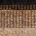 Detailopname van het Perletta Limone Fade Yellow vloerkleed met geweven structuur in aardetinten en gele accenten.