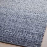 Detailopname van het blauwgrijze Perletta Limone Fade vloerkleed met grove geweven structuur.
