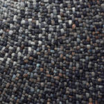 Detailopname van een geweven Perletta Roundabout Fade Blue vloerkleed met blauwgrijze en bruine kleuraccenten.