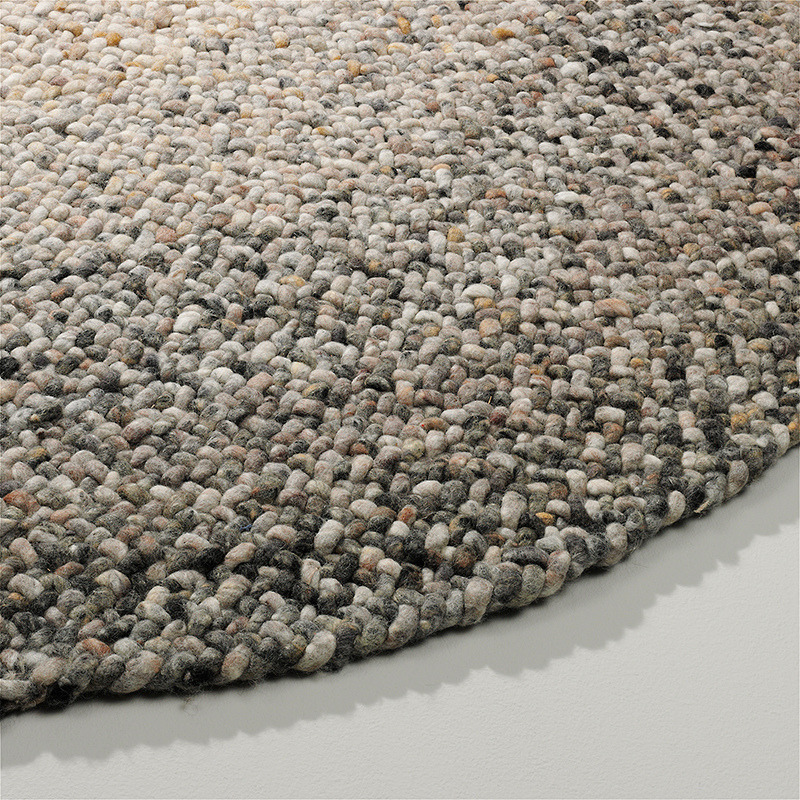 Detailopname van het ronde Perletta Roundabout Fade Brown vloerkleed met grove geweven textuur in bruine en grijze tinten.