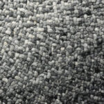 Detailopname van het grijs verlopende, handgeweven oppervlak van het Perletta Roundabout Fade Grey vloerkleed.
