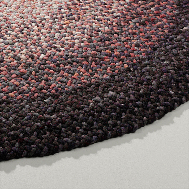 Detail van het ronde Perletta Roundabout Fade vloerkleed in paarstinten met een geleidelijk kleurverloop.