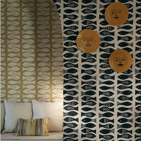 Sfeervolle interieurhoek met Pierre Frey Cancale behang met vispatroon en decoratieve borden aan de muur.