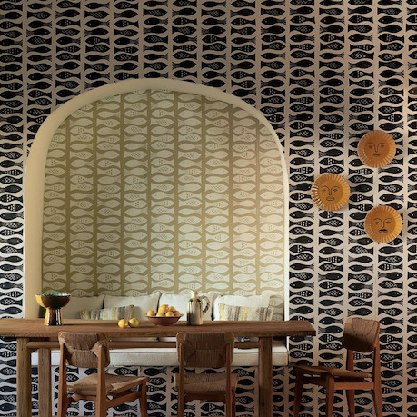Eetkamer met Pierre Frey Cancale-behang met vispatroon in nis en op muur, gecombineerd met houten meubels en decoratieve zonwandobjecten.