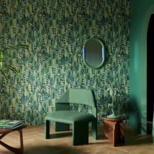 Groene kamer met tropisch Pierre Frey La Désirade behang, moderne stoel en houten bijzettafel.