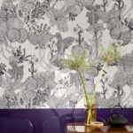 Zwart-wit Pierre Frey Punta Cana behang met tropisch botanisch motief in een sfeervol interieur met paarse muur en decoratieve accessoires.