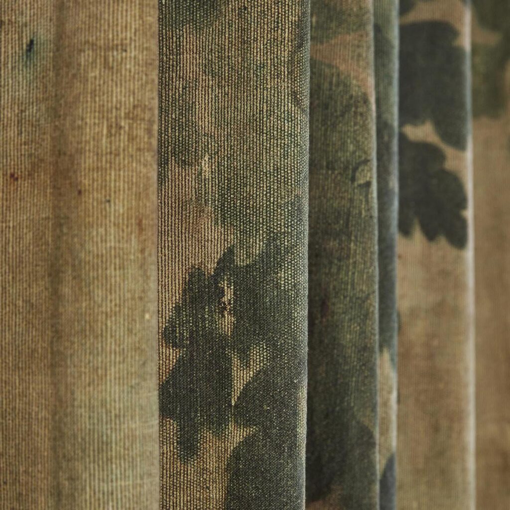 Close-up van geplooide Pierre Frey-stof ‘Au Bord du Lac’ met een natuurprint in groentinten.
