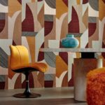 Moderne interieurruimte met felgele designstoel, marmeren tafel, turquoise vaas en kleurrijk geometrisch behang met abstract motief uit de Puzzle1-4HUY-2 serie.