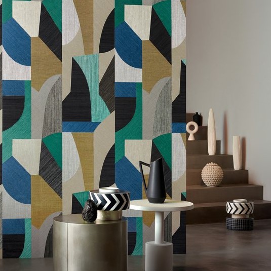 Kleurrijk geometrisch behang uit de Puzzle2-I7A4-2 serie in een modern interieur met decoratieve objecten en bijzettafels.