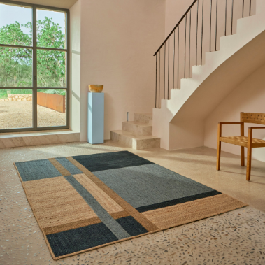 Modern interieur met Elitis Saphir TA 137 40 04 vloerkleed in aardetinten en geometrisch patroon.