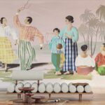 Muurschildering met kleurrijke figuren in traditionele kleding die dansen en socializen in een tropisch landschap, met moderne meubels op de voorgrond.