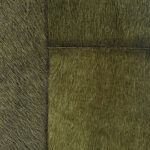 Detailopname van een olijfgroen patchwork tapijt van koeienhuid, model VP-618-15.