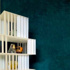 Moderne witte wandkast Alcove 2 met decoratieve objecten tegen een diepblauwe muur.