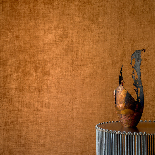Keramisch kunstobject op een ronde metalen tafel voor een warmbruine Alcove 2 RM 41070 wandbekleding.
