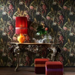 Sfeervolle interieursetting met Arte Blooming Pineapple behang, een sierlijke tafel, oranje lamp en kleurrijke poefjes.
