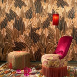 Interieur met Arte Pavartina 97562 behang in bruin- en goudtinten, een sierlijke fauteuil met franjes, poef en rode lamp.