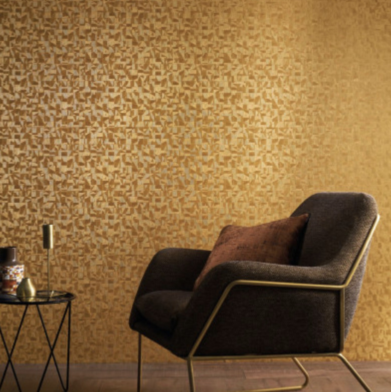 Donkerbruune fauteuil met koperen frame staat voor een okergele muur met Casamance Tiznit behang met abstract patroon.