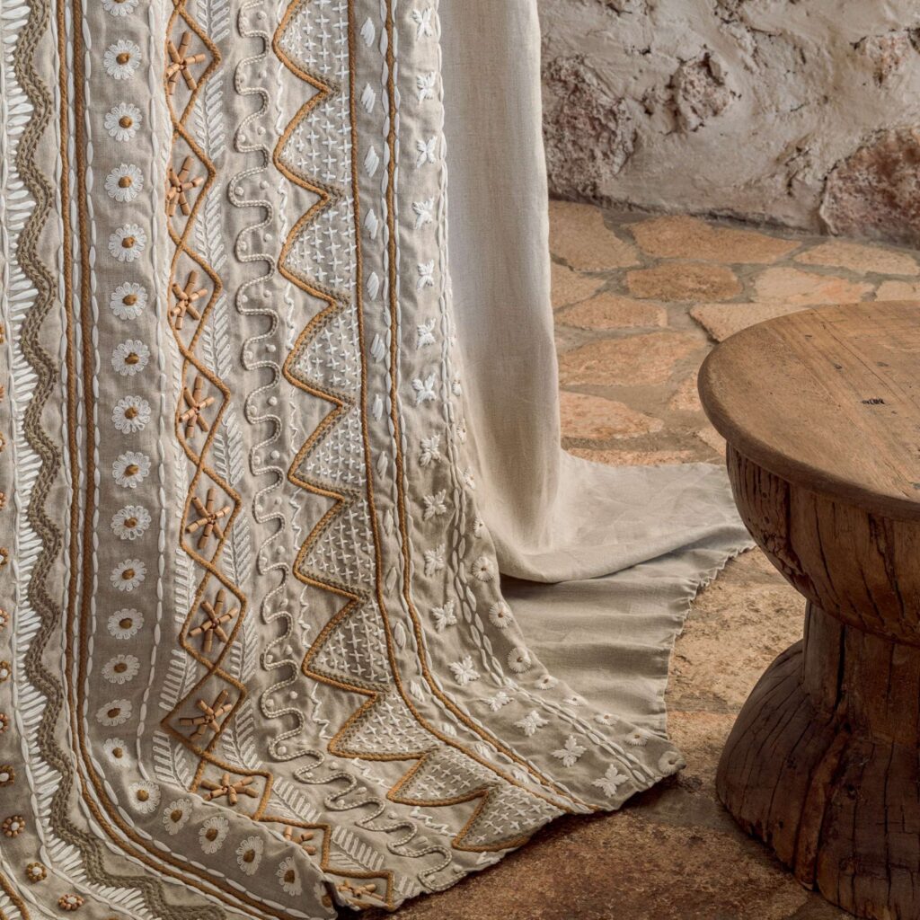 Linnen Elitis Baleares Menorca LZ 899 03 stof met decoratief borduursel in een rustieke interieursetting.