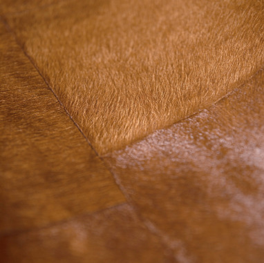 Detail van Elitis behang Sauvages VP 618 13 met een textuur die doet denken aan bruin dierenhuidleer.
