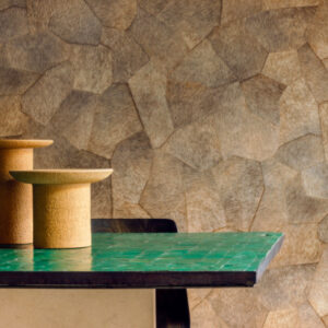 Groene tafel met kurken decorstukken voor een muur met Elitis Sauvages behang in aardetinten.